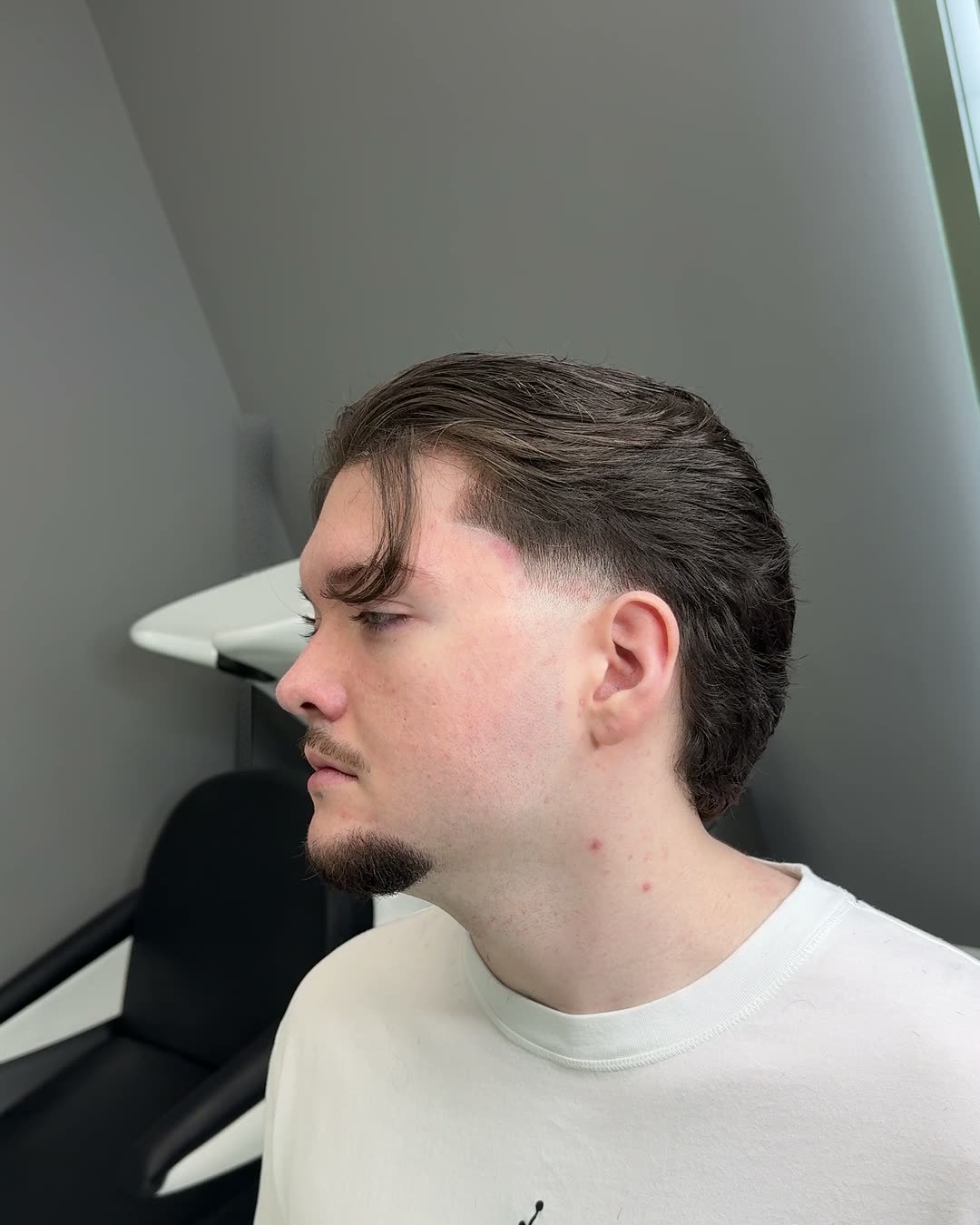 Low taper fade with a swept-back top by Cuts By Cello